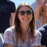 Katherine Daly, a young woman with long brown hair wearing plaid shirt and sunglasses