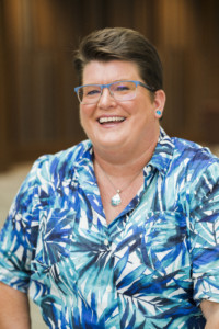 Robin Craig, a middle-aged woman with short brown hair wearing blue-rimmed glasses and a blue blouse