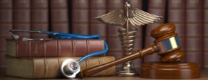 Gavel, stethoscope and caduceus sign on books background.