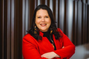 Elizabeth Kronk Warner, a Native woman with white skin and dark-brown hair wearing a red blazer