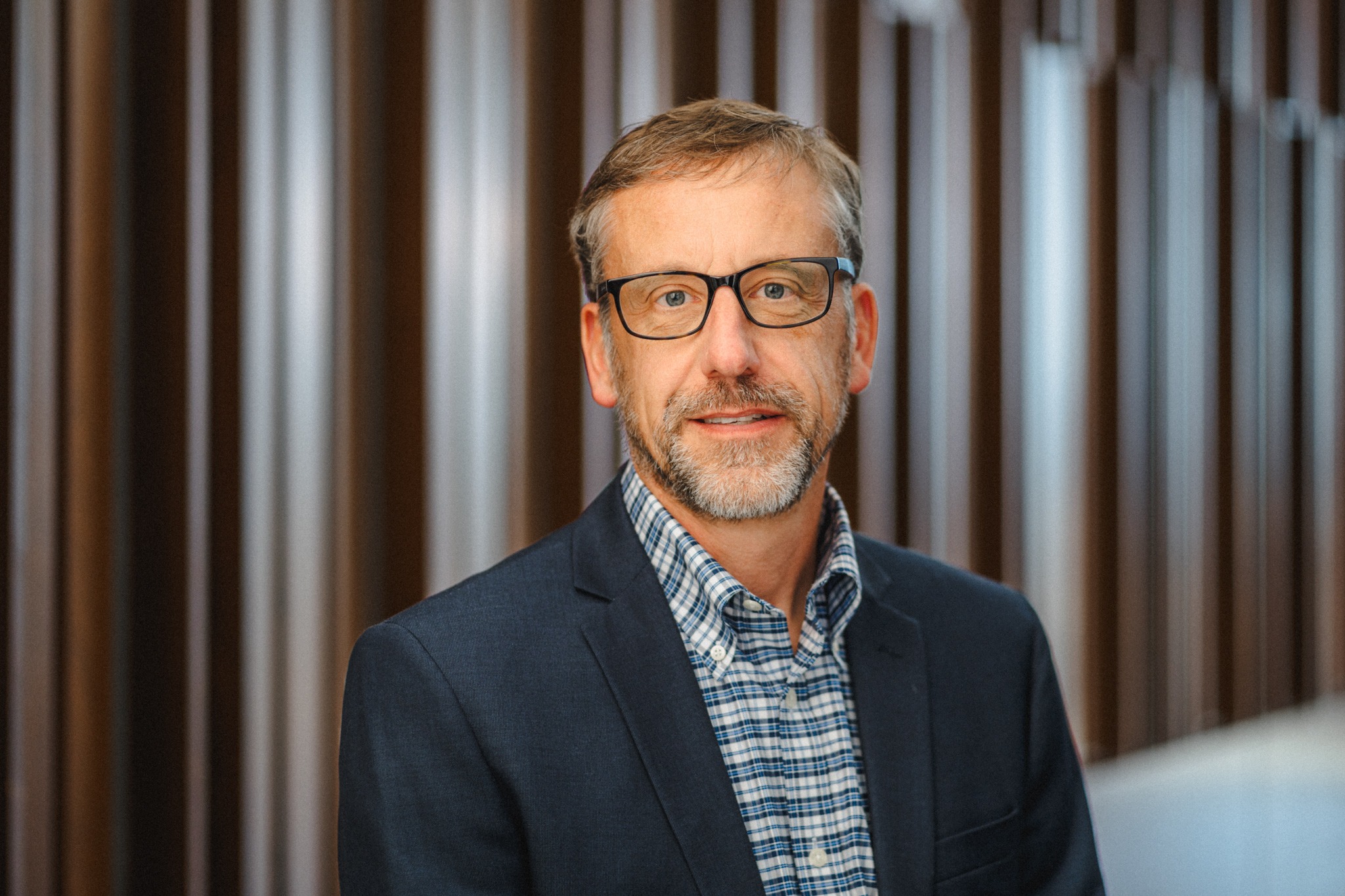 Professor John Ruple, a middle-aged white man with dark blonde hair, and short grey beard with dark spectacles