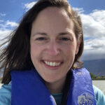 Emily Crockett, a young woman with short brown hair wearing a raft life vest