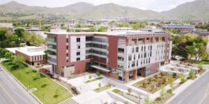 Red brick exterior of College of Law building with grass surrounding in and mountains in the background