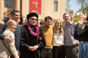 F. Bryant McOmber, center (in black graduation cap and gown) stands outside Kingsbury Hall with his family after convocation