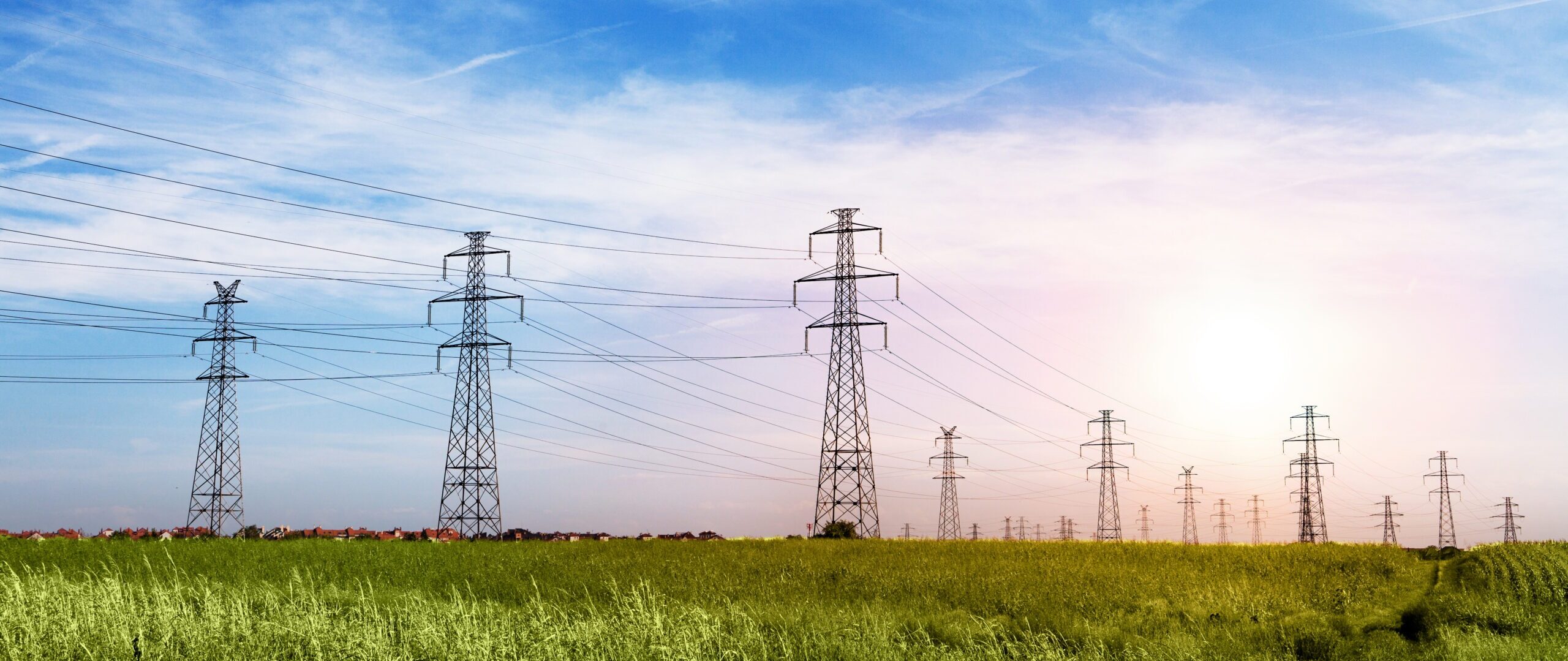 Landscape of Power Line of the Electric Wires at the Blue Sky on the Green Grass