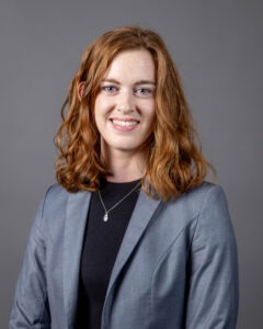 Claire Munsell, a young white woman with shoulder-length wavy red hair