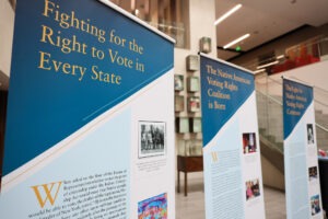 Hanging banners with photos and text from the American Bar Association’s (ABA) traveling exhibit, “Native American Voting Rights: A History of Struggle and Triumph.” 