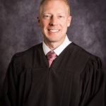 Judge Brian D. Bolinder, a young white man with short strawberry-blonde hair and grey eyes wearing a black judge robe